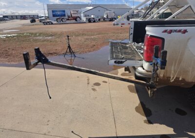 4x4 pickup with hitch-mounted bed extender, tailgate down; setup for hauling long lumber, pipe or ladders.